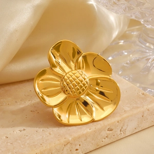Polished 18K gold-plated stainless steel chunky flower ring on a neutral stone surface