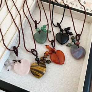 Close-up of heart-shaped natural stone pendants with hand-woven rope necklaces