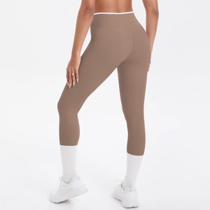 Détail du pantalon de yoga taille haute avec design bicolore marron et coutures galbantes