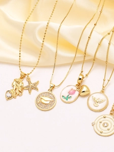 Detailed close-up of varied gold pendants with zircons and enamel on satin backdrop