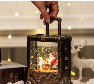 Detail of vintage bronze Christmas lantern snow globe showing a handheld festive scene