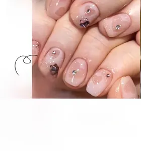 Détails de faux ongles rose gelée avec motifs de cœurs évidés et paillettes brillantes