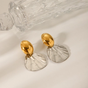 Detail of two-tone oval gold and silver fan-shaped earrings with vertical stripes texture
