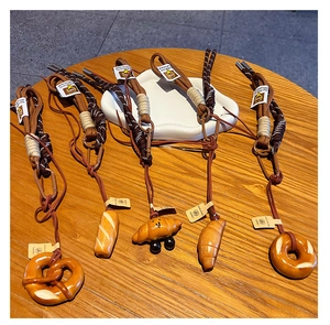 Detailed view of creative resin pastry charms with woven ropes on a wooden surface