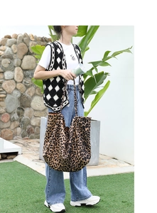 Fashionable leopard print canvas tote bag shown with casual outfit in an outdoor setting