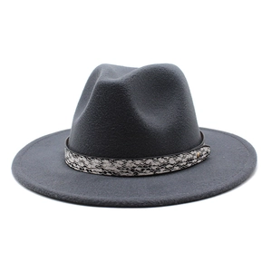 Detail of dark grey wool fedora hat featuring snake print band and gold metal studs