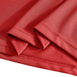 Detailed macro view of red pique fabric texture with double-needle stitching on hem