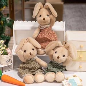 Tre coniglietti di peluche dalle orecchie lunghe in abiti a quadri con pizzo