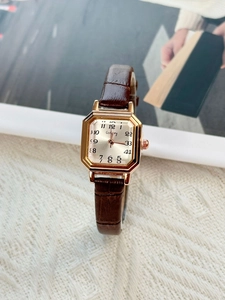 Close-up of octagon rose gold watch with cream dial and brown croc leather strap