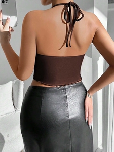 Back view of a sexy halter neck knit crop top and leather skirt on a fashion model