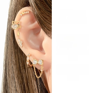 Detail of gold titanium steel ear piercing set with cat and star zircon charms