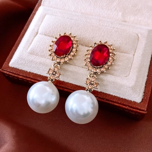 Close-up of vintage oval red gemstone earrings with pearls in a luxury jewelry box