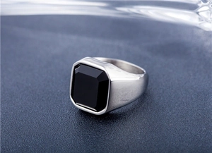 Détail macro d'une bague homme en acier argenté avec une pierre d'onyx noire carrée