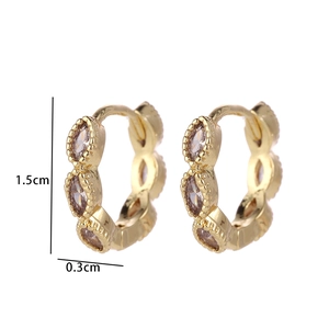 Macro shot of gold-plated hoop earrings with three marquise zircon stones and bead edges