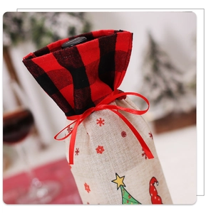 Detail of linen Christmas wine bottle cover with red plaid pattern and snowflake prints
