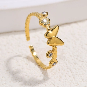 Detailed close-up of golden stainless steel ring with butterfly, flower and zircon accents