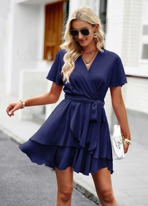 Détail de la robe bleu foncé à col en V avec taille lacée et ourlet à volants