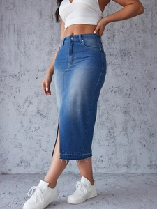 Détail de jupe midi en jean taille haute montrant l'ourlet brut et la fente avant