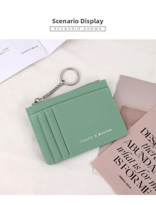 Green cross-grain leather card holder with key chain shown on minimalist aesthetic background