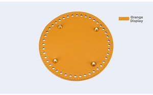 Detail of round orange PU leather bag base with gold metal feet and pre-punched holes