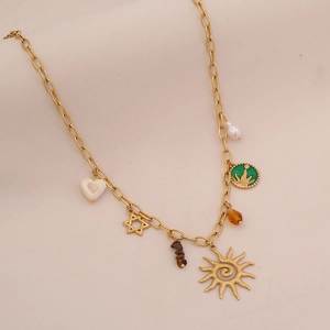 Detail of vintage gold necklace featuring sun, star, and heart charms on a wide chain
