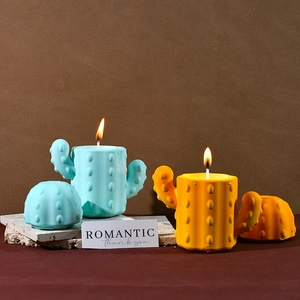 Close-up of lit cactus scented candles in blue and yellow silicone storage jars