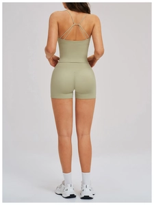Detail view of the criss-cross back sports bra and high-waisted shorts in sage green