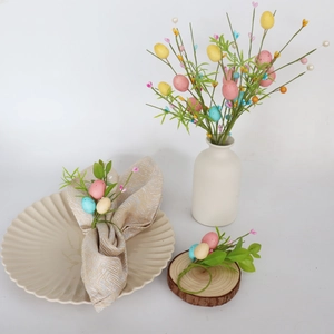Close-up of Easter egg napkin ring with colorful foam eggs and artificial green leaves
