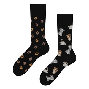 Detail of asymmetrical black socks featuring coffee beans and cup patterns on white background