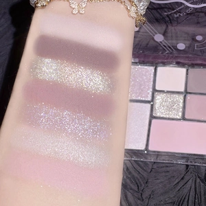 Detaillierte Arm-Swatches der 9-Farben Lidschattenpalette in matten Rosa- und Glitzertönen