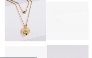 Detail showing gold double-layer necklace with hollow tree of life heart and bead charms