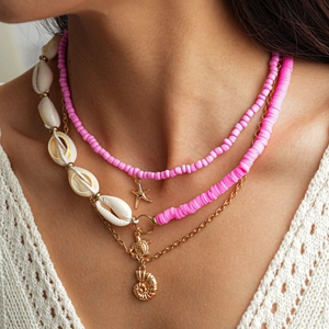 Detail of layered beach necklace set with gold starfish, conch shell and sea turtle charms