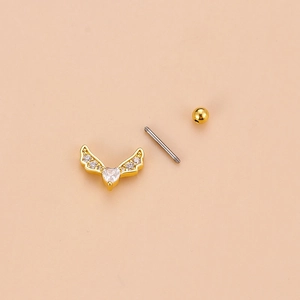 Macro detail of golden heart wing stud earring with cubic zirconia and screw ball back