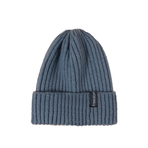 Detailed texture of thick dark blue ribbed knit hat with a white Freedom logo patch
