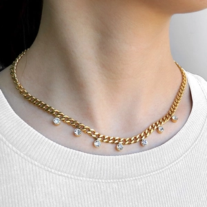 Gold Cuban chain necklace with seven circular zircons worn on model with white knit collar