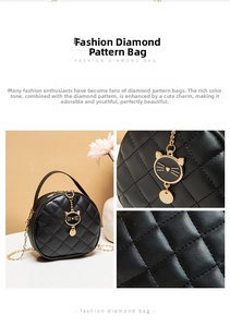 Detail of black quilted round mini bag featuring a gold cat charm and metal chain strap
