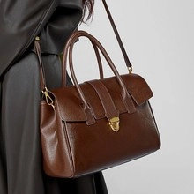 Nahaufnahme der braunen Vintage-Lederhandtasche mit Goldverschluss und feiner Textur