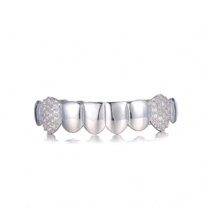 Macro shot of silver plated hip hop grillz with sparkling white zircon stones set on white