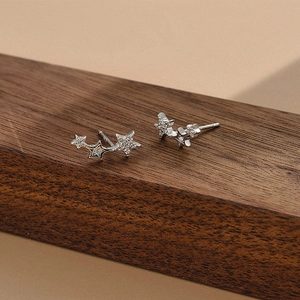 Macro shot of 925 sterling silver star stud earrings with zircons on dark wood
