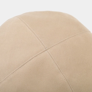 Detailed view of beige corduroy fabric and cross-stitching on a beret hat top