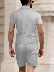 Vista posteriore del set polo e pantaloncini in maglia grigio chiaro da uomo all'aperto