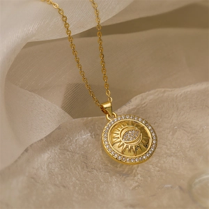 Close-up of gold sunburst necklace pendant with an eye motif and sparkling zircons