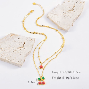 Close-up of golden double-layer necklace with red cherry pendant and 46cm length detail