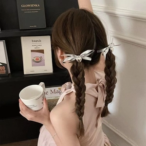 Elegant silver ribbon bow hair ties with heart pendants on a braided hairstyle