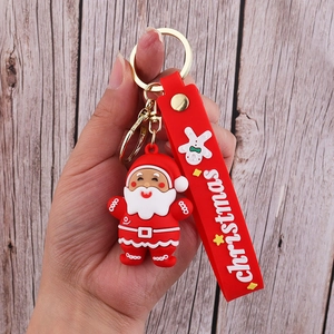Detailed macro of a red PVC Santa Claus keychain with a Christmas silicone wrist strap
