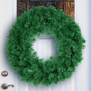 Lush green artificial Christmas wreath hanging on a minimalist white door