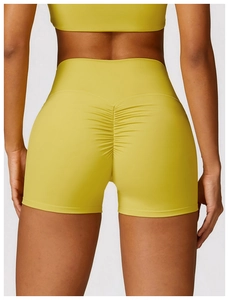 Détail macro du short de yoga taille haute montrant la texture froncée jaune moutarde