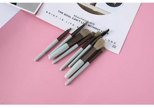 Detail view of 8-piece mini makeup brush set in light blue with soft brown bristles