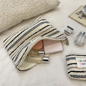 Detail of striped knitted cosmetic bags in different sizes with zipper closure
