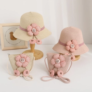 Close-up of summer straw hats and matching crossbody bags with fabric flowers and cherries